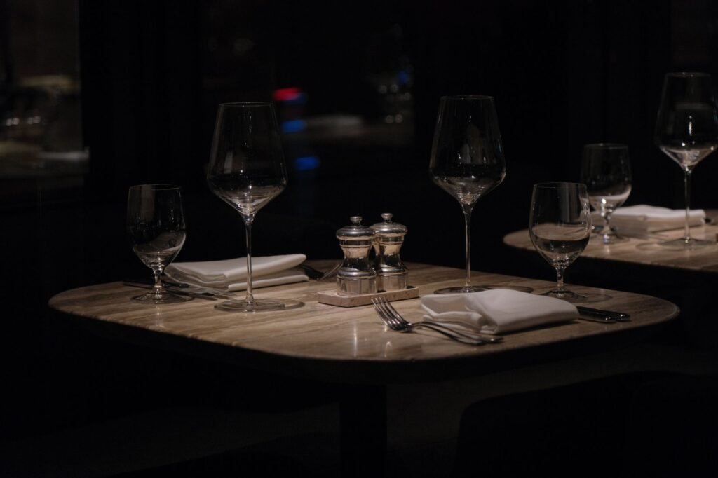 A sophisticated restaurant table setting with wine glasses, napkins, and cutlery, perfect for a romantic evening.