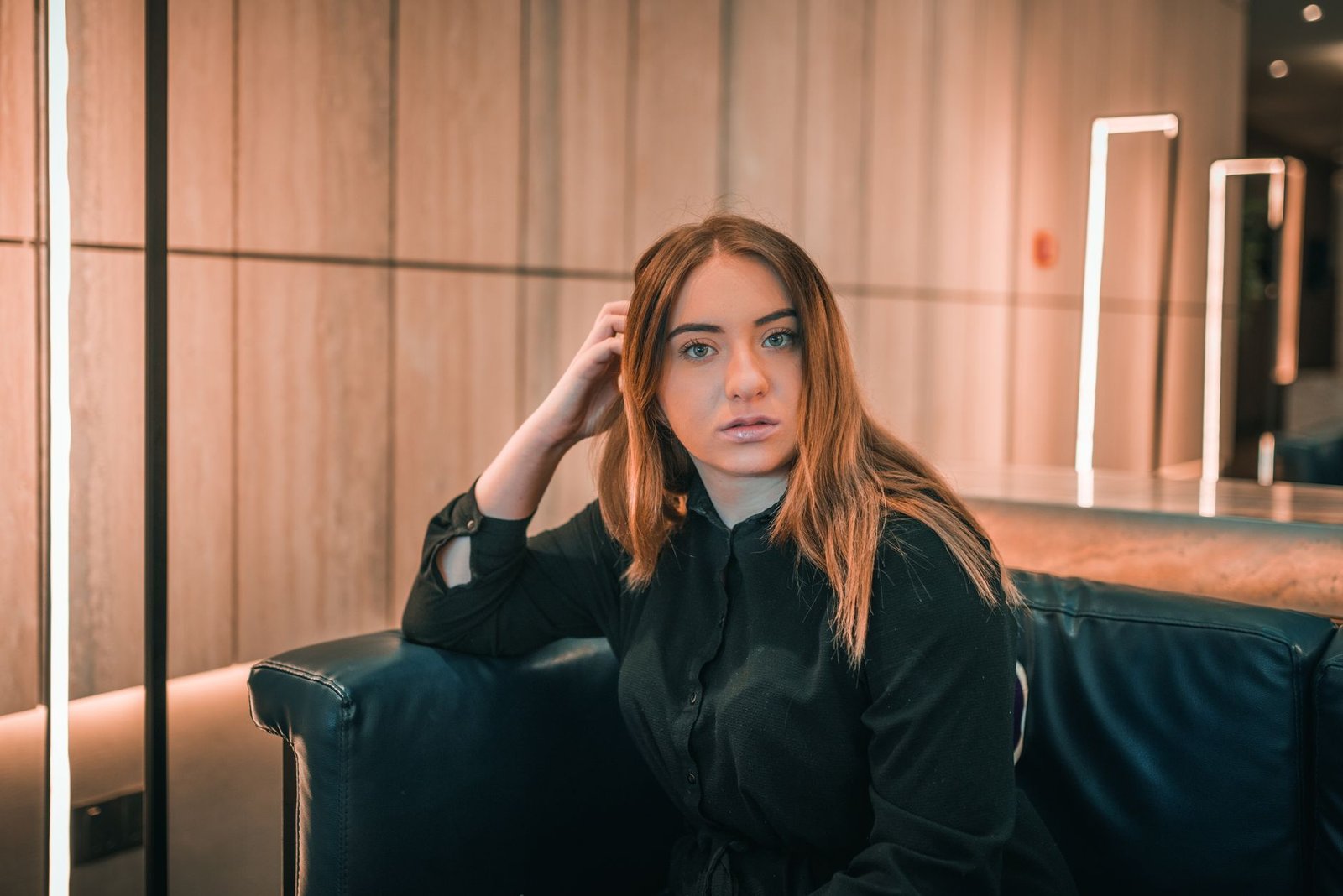 Stylish portrait of a young woman sitting indoors with modern decor in Dubai.
