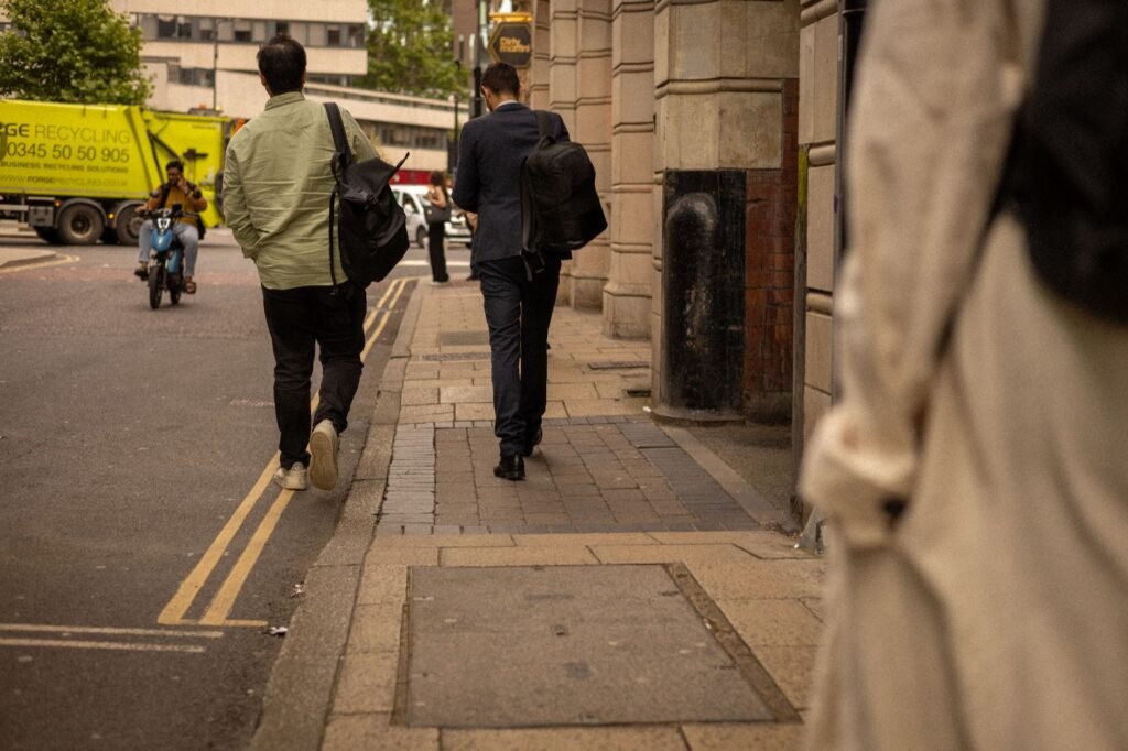 Daily hustle in the streets of Leeds, showcasing people walking past buildings and traffic.