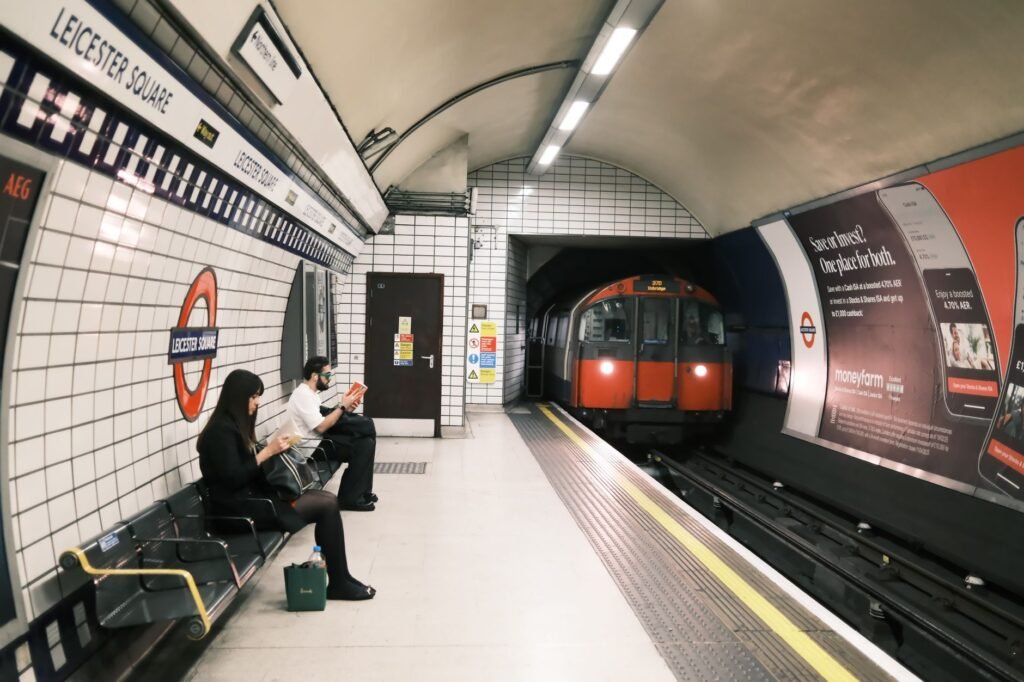 Passengers wait as a train arrives at Leicester Square Tube station in London.