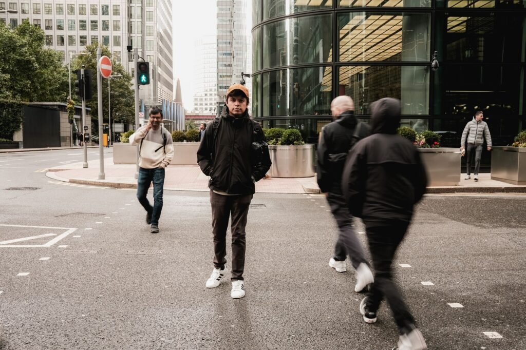Urban street scene in London showing pedestrians crossing at a crosswalk near modern buildings.