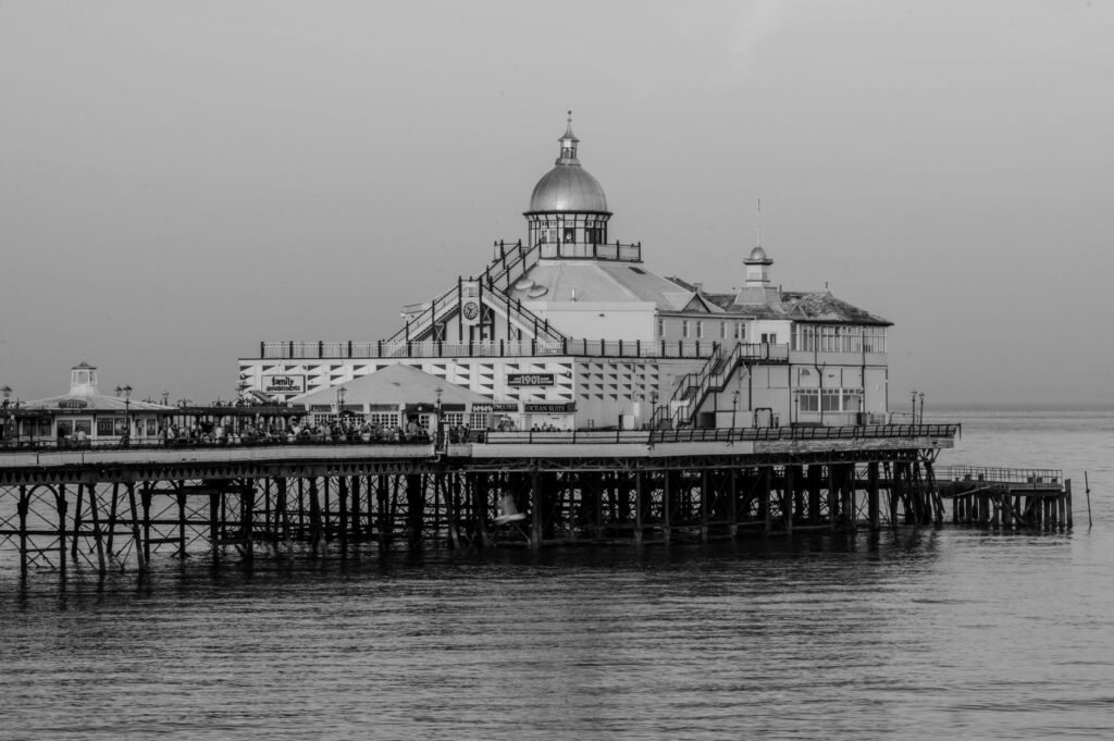 Monochrome photo of the iconic Eastbourne Pier extending into the calm sea.