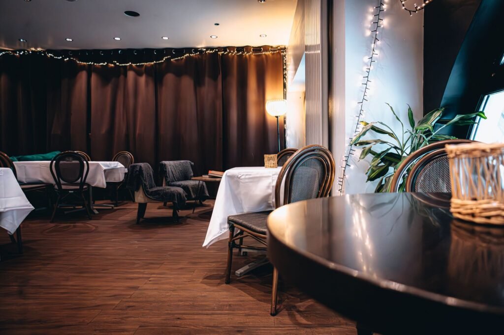 A warmly lit restaurant interior featuring elegant decor and wooden furniture, perfect for intimate gatherings.