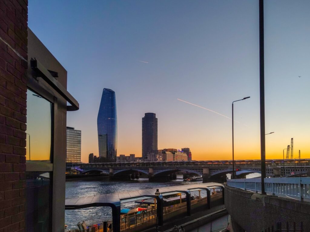 Stunning sunset over London skyline featuring iconic modern architecture and cityscape reflections by the Thames River.