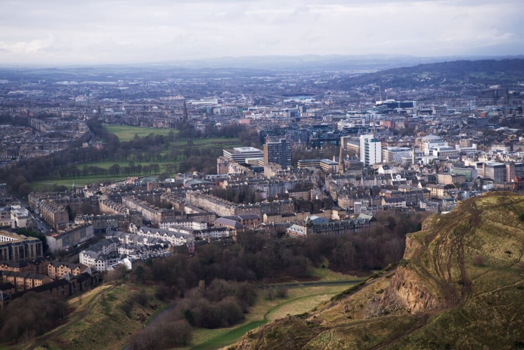 A breathtaking aerial view of Edinburgh cityscape from Arthur's Seat, showcasing vibrant urban architecture and natural lands