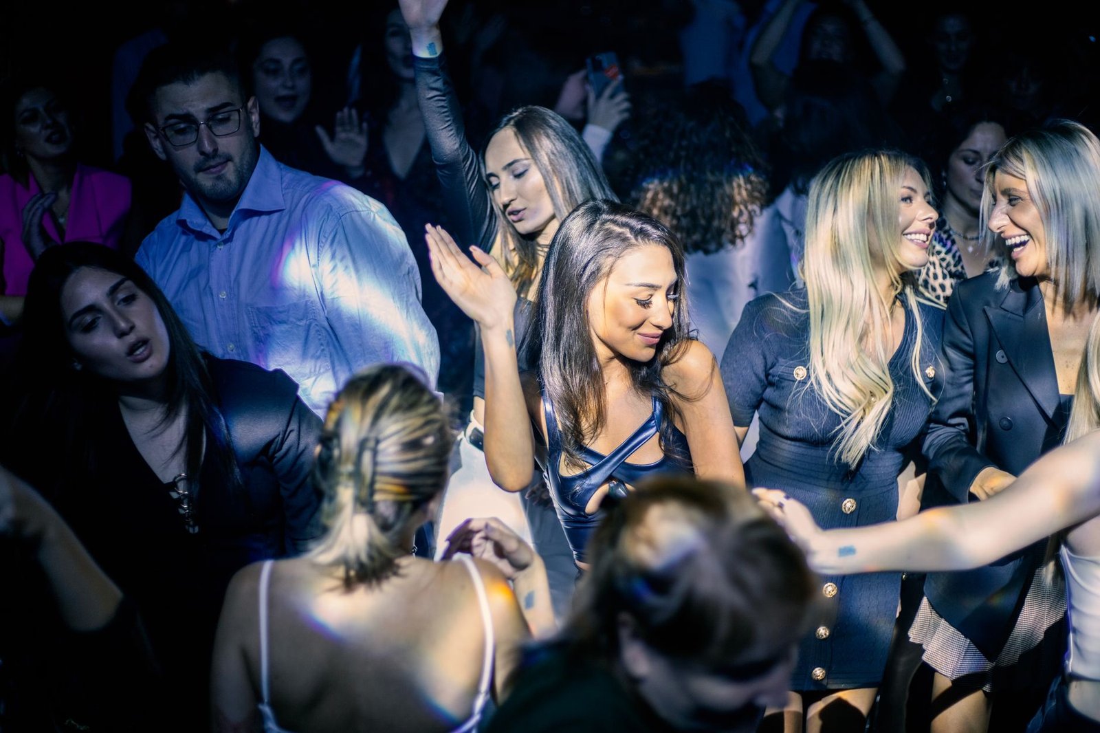 Young adults enjoying a vibrant night out at a lively nightclub dance floor.