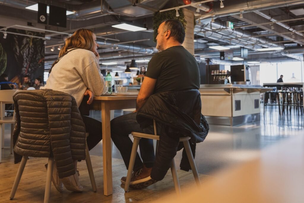 Two adults engaging in conversation at a stylish Zagreb cafe, showcasing a relaxed atmosphere.