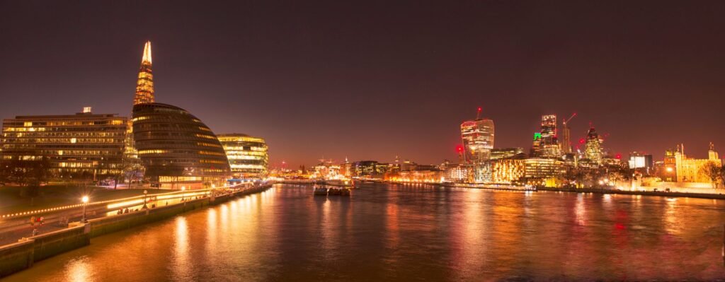 Stunning nighttime view of London's illuminated skyline along the River Thames.