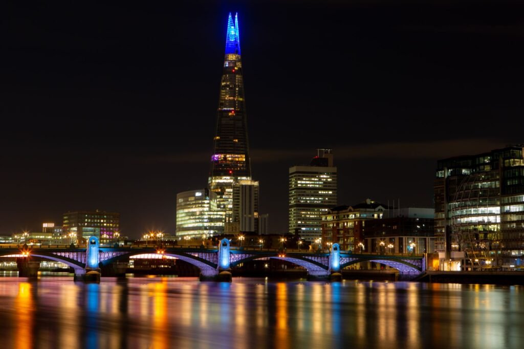 Stunning London night skyline with illuminated Shard and river reflections.