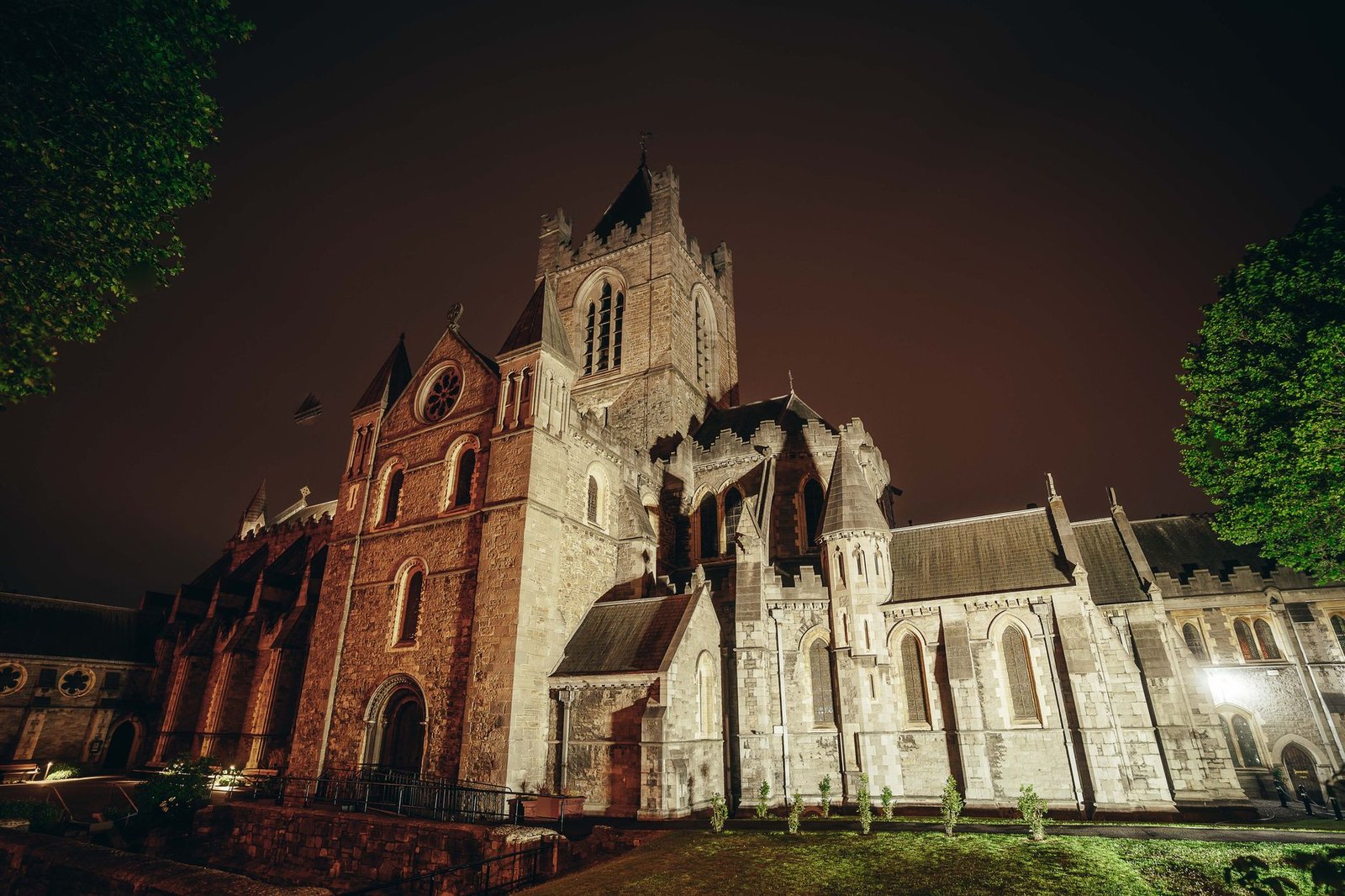 Illuminated Christ Church Cathedral in Dublin at night, showcasing its Gothic architecture.