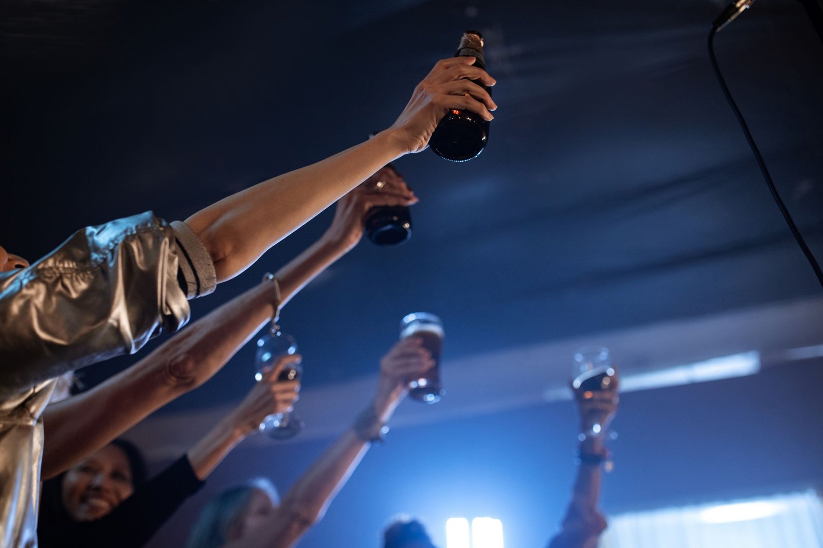 Joyful gathering at a bar with people raising drinks in celebration, creating a lively nightlife scene.