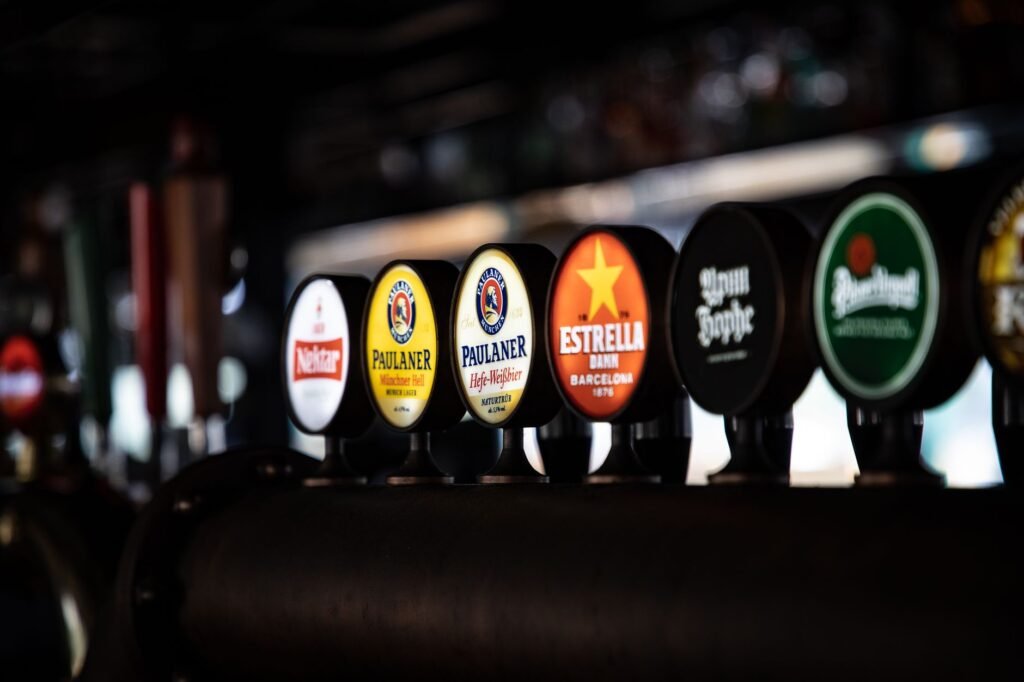 A close-up shot of various beer taps on display in an indoor bar environment.
