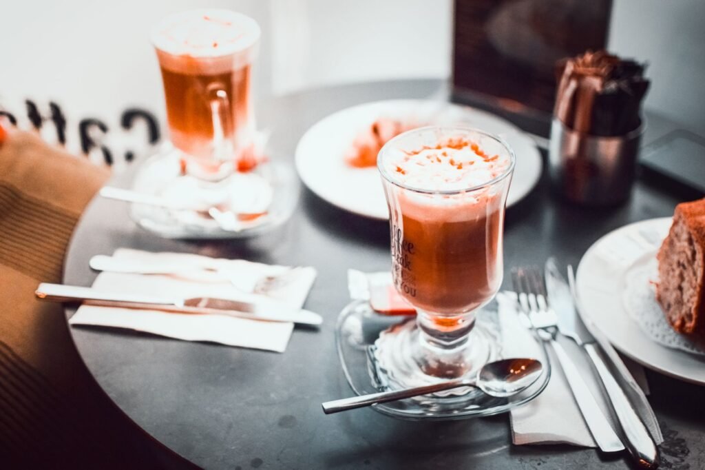 Close-up of cappuccino and dessert on a cafe table, showcasing a cozy and indulgent vibe.