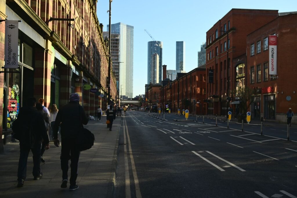 An urban street view showing pedestrians and skyscrapers under a clear blue sky.