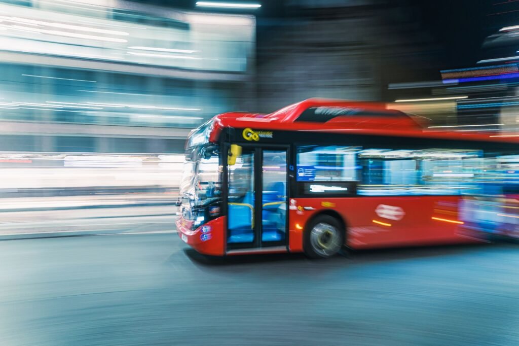 Captivating panning shot of a moving red London bus, highlighting dynamic urban nightlife.