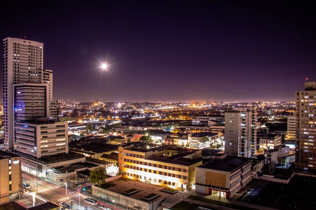 Stunning aerial view of Curitiba at night showcasing illuminated skyscrapers and vibrant city life.