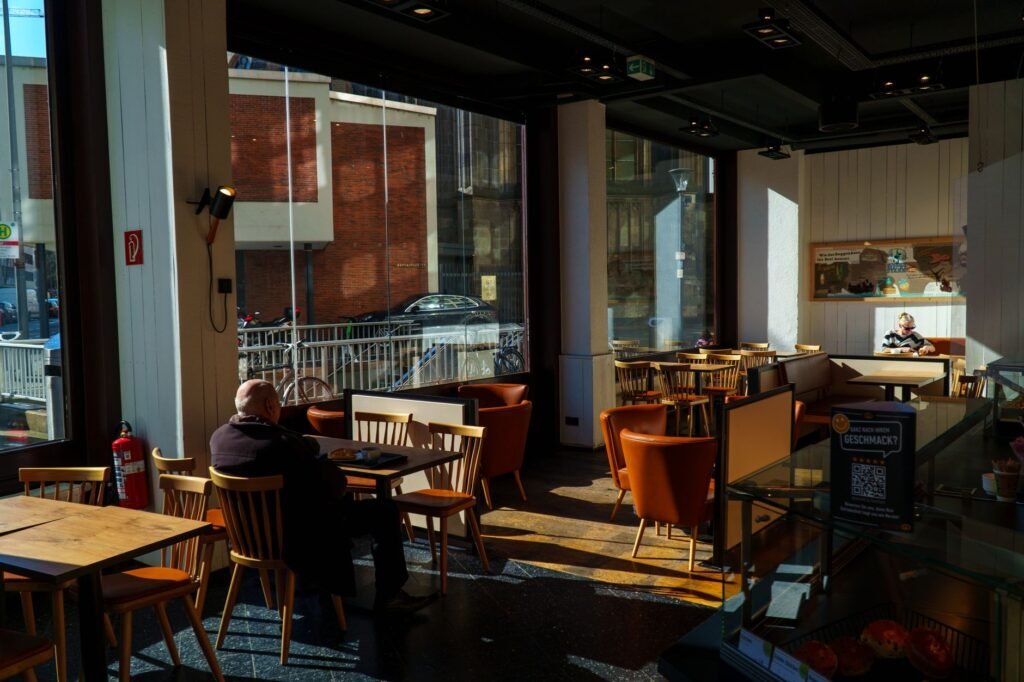 Warm sunlight fills a stylish café in Cologne, perfect for a relaxing coffee break.