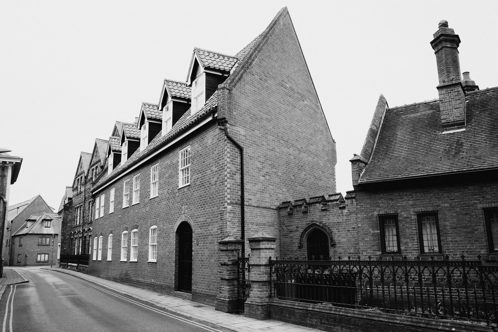 Charming black and white photo of historic brick architecture on a quiet street in King's Lynn, England.