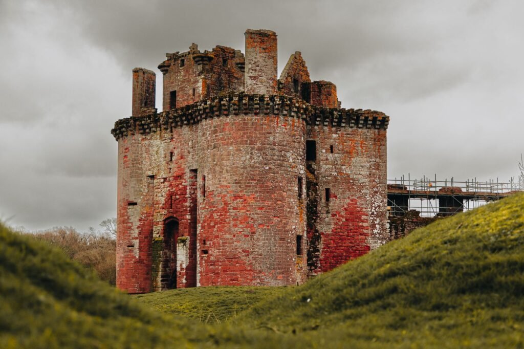 Old Caerlaverock Castle in Scotland on an overcast day, showcasing its historic architecture.