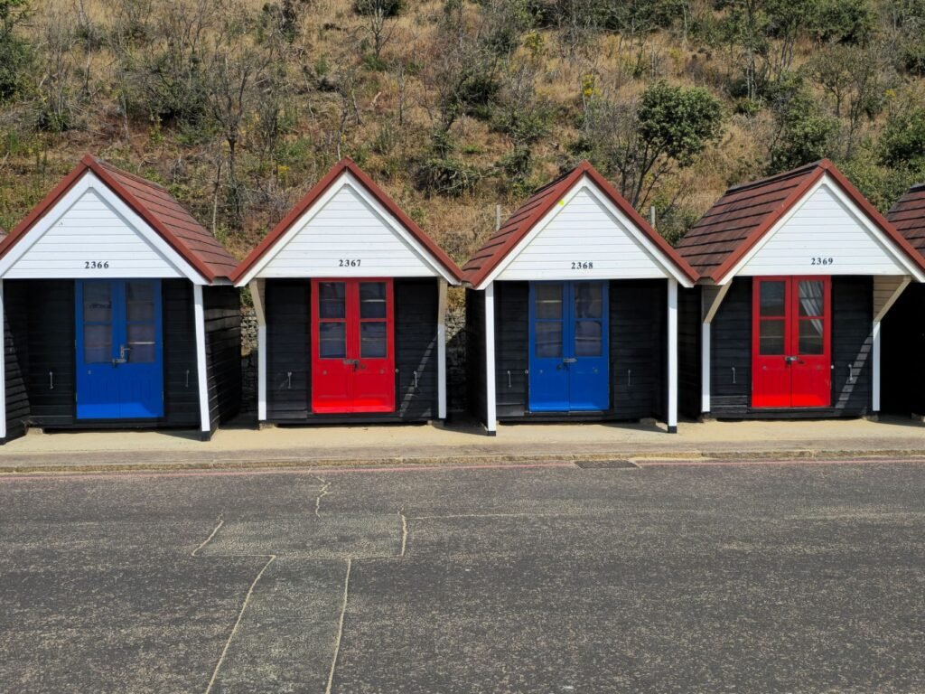 A row of vibrant beach huts with numbered doors in Bournemouth, England.