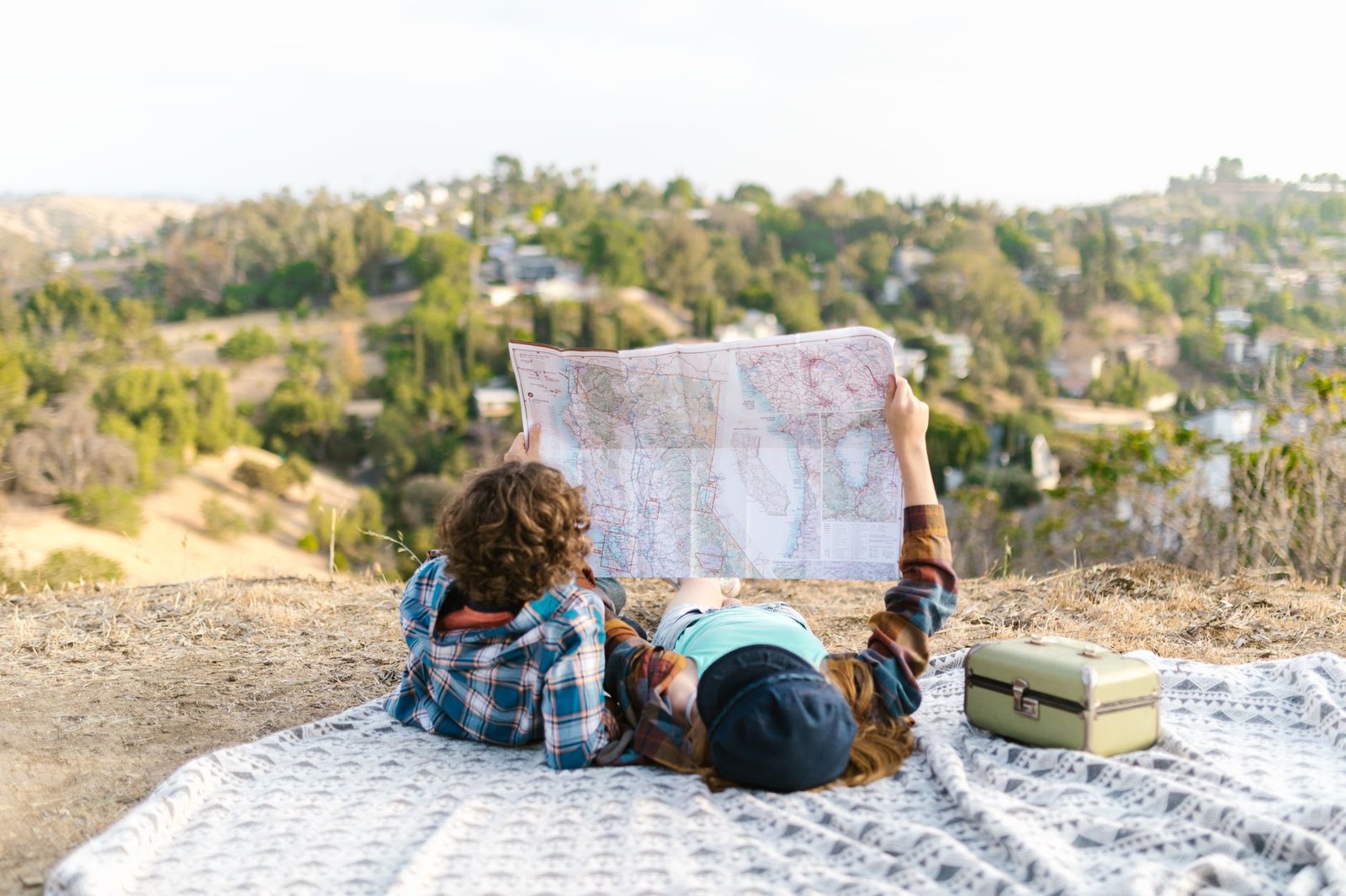 Two adults planning a romantic weekend break with a map and notebook