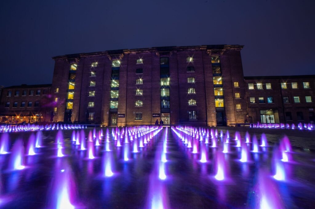 Stunning night scene of illuminated fountains at King's Cross, London.