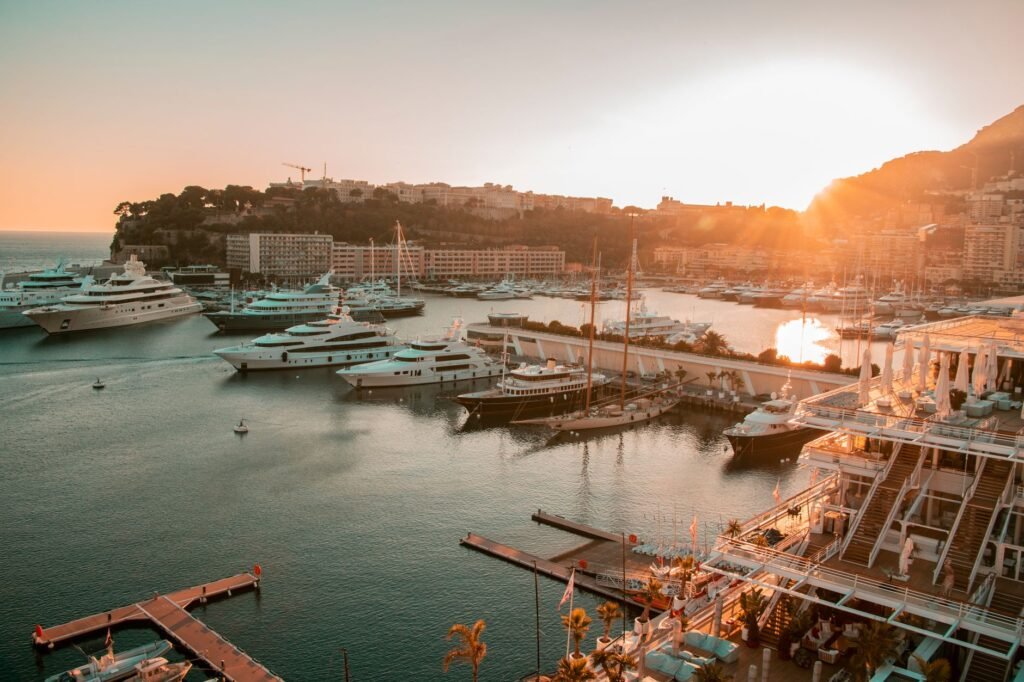 Stunning view of yachts in Monaco harbor at sunset, showcasing luxury and tranquility.