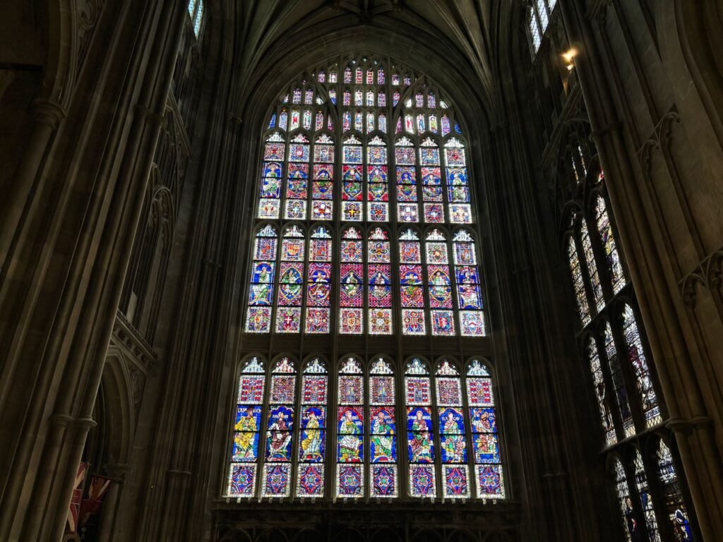 Stunning stained glass window in Canterbury Cathedral, showcasing intricate designs and vibrant colors.