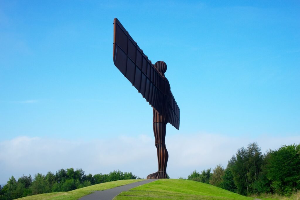 Iconic Angel of the North statue with a striking blue sky background in Newcastle, England.