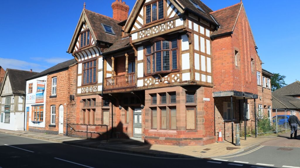 Historic Tudor-style building in Nantwich, England under clear blue skies.