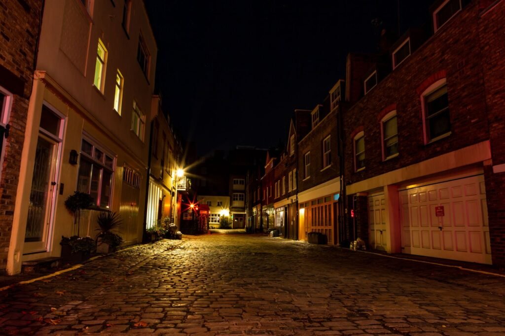 Serene cobblestone alley in London with warm lighting highlighting historic architecture.