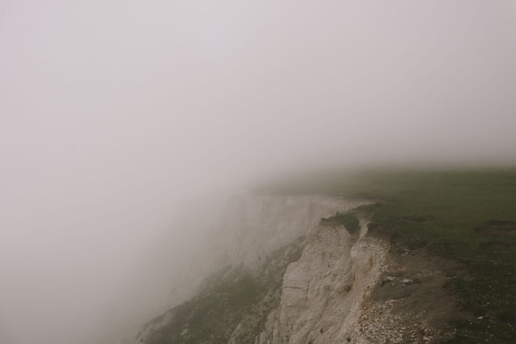 Captivating view of Eastbourne's cliffs shrouded in dense fog, creating a mystical and serene landscape.