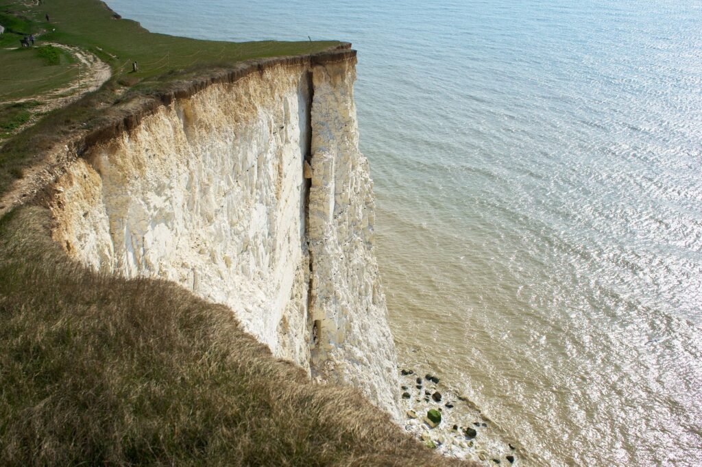Majestic white cliffs in Eastbourne, UK overlooking the sea, under a clear sky.