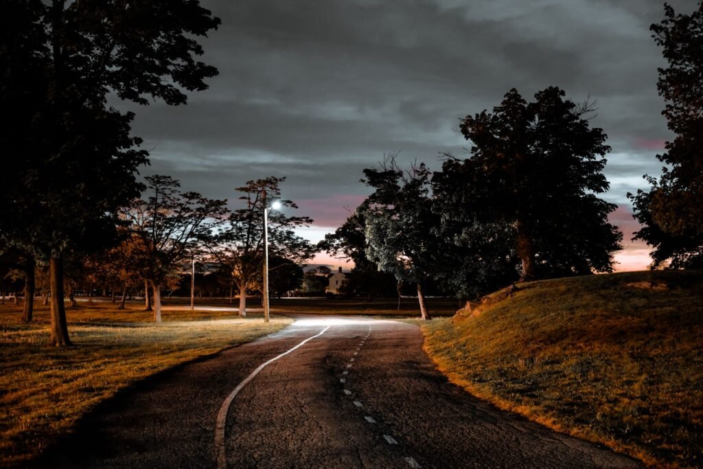 Captivating evening scene in Stamford park, with illuminated paths and overcast sky.