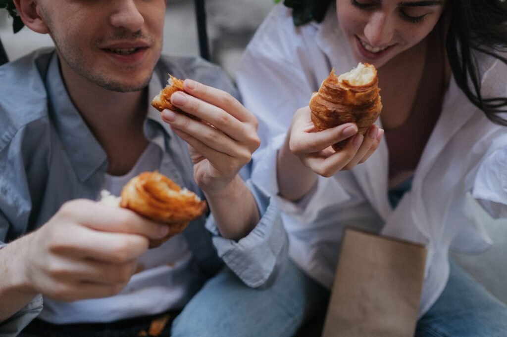 A young couple sharing a delightful breakfast with fresh croissants, enjoying a cozy morning.