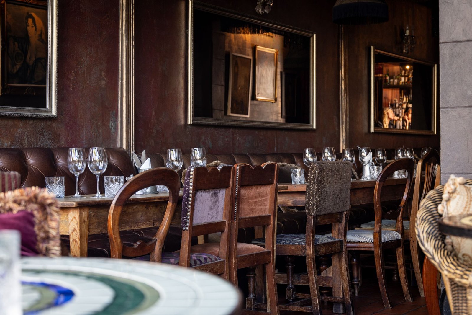 Charming restaurant setting featuring a rustic wooden table, elegant glassware, and vintage-style chairs.