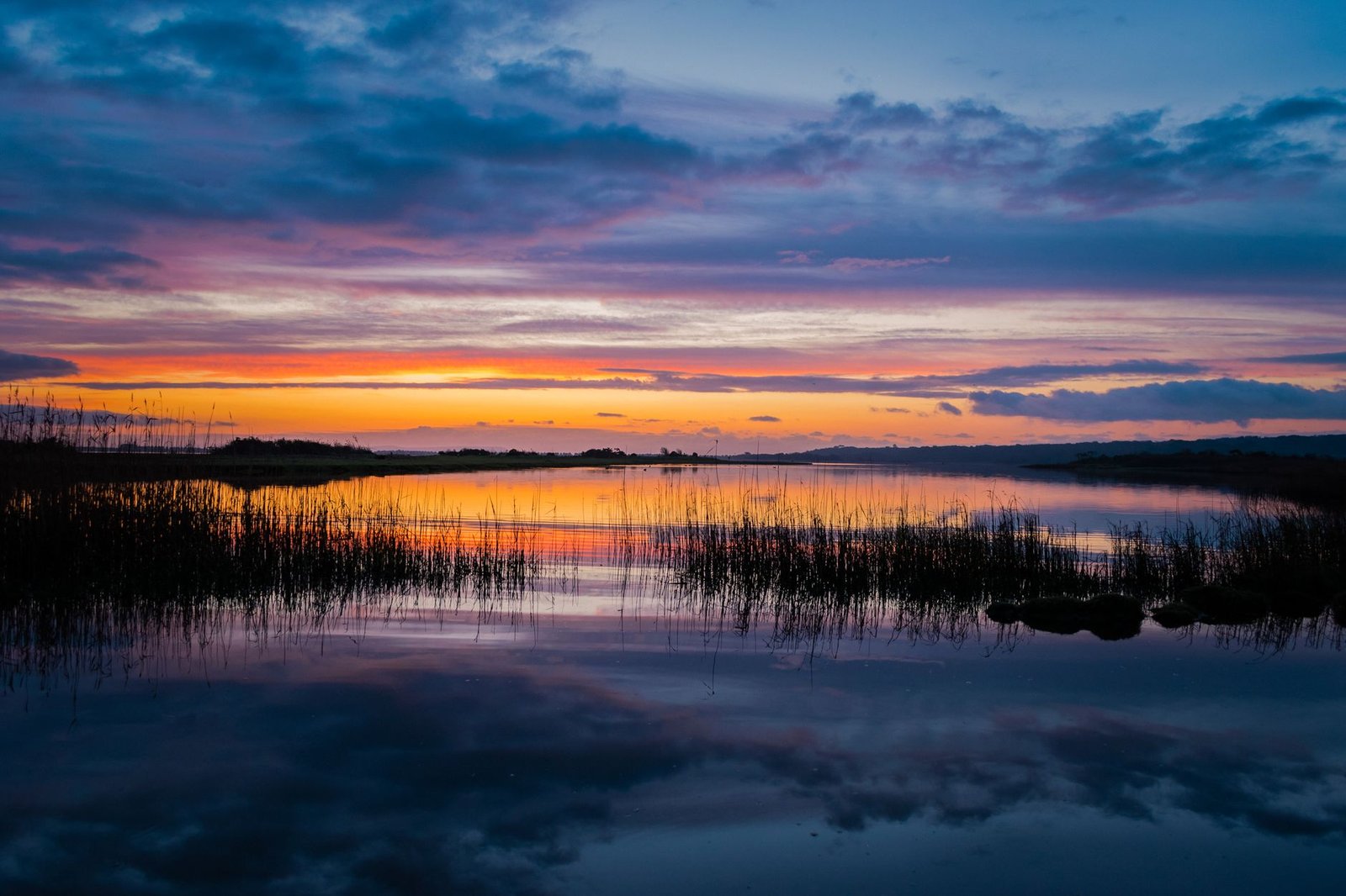 Beautiful sunset over a calm lake with vibrant sky reflections. Perfect nature and tranquility capture.