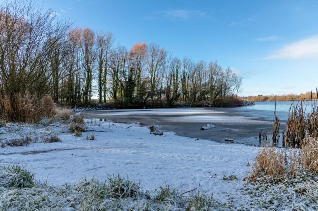 A serene winter scene with a frozen lake and snow-covered landscape in Tullygally, Northern Ireland.