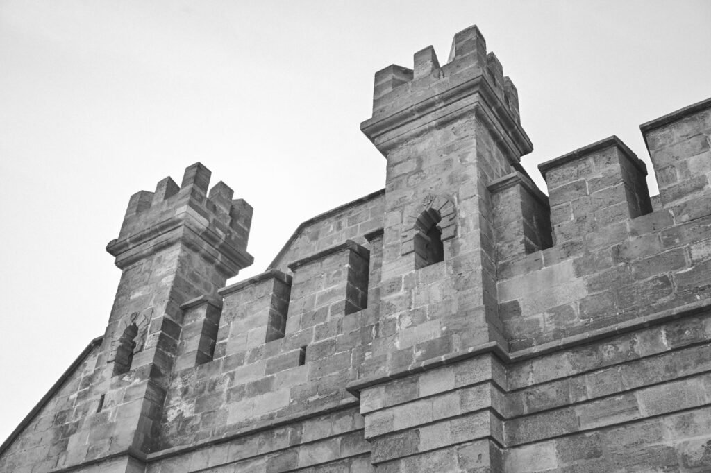 Black and white photo of a historic stone castle with turrets.