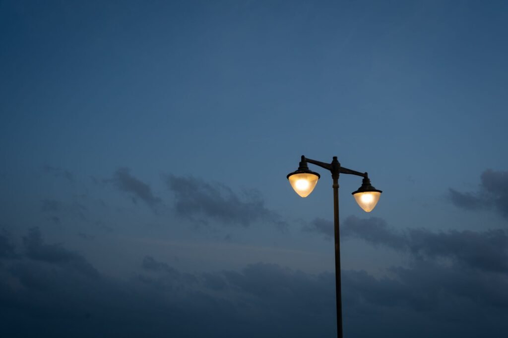 A street lamp illuminates against a twilight sky, creating a serene urban evening scene in Colombo, Sri Lanka.