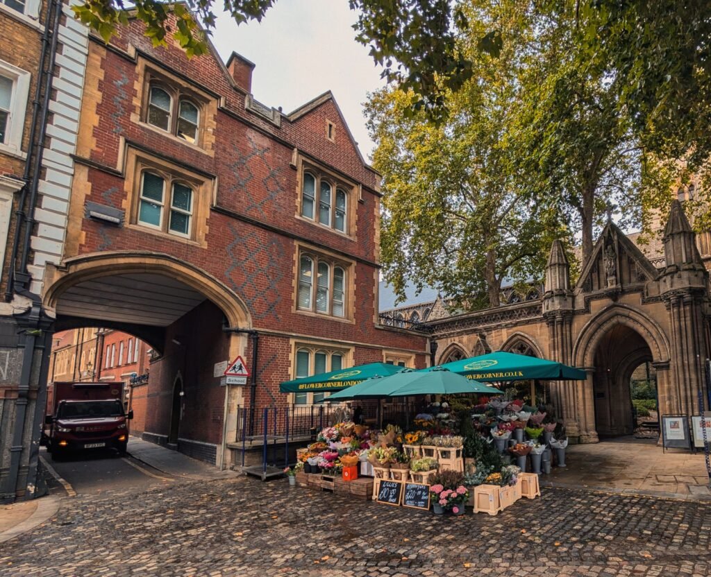 Explore a delightful flower market set amidst classic Gothic architecture in London, highlighting a street scene full of vibr