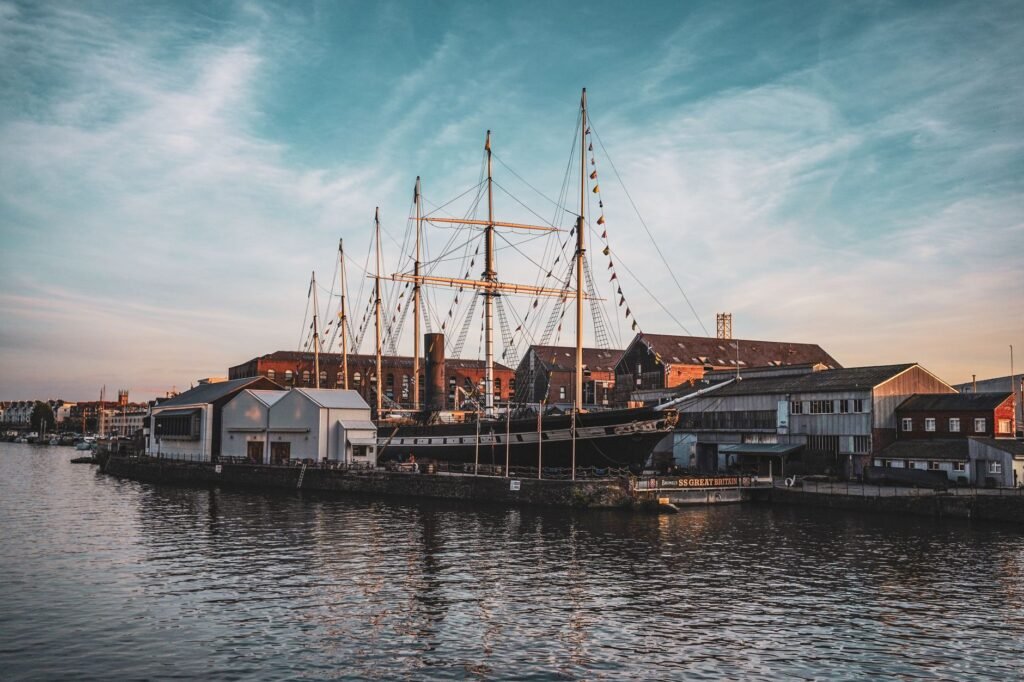 A majestic ship in a bustling urban harbor at sunset, reflecting the beauty and history of maritime heritage.