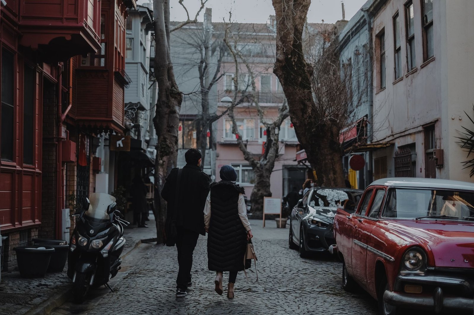 Man and woman walking on a cobblestone street in historic Istanbul, Turkey.