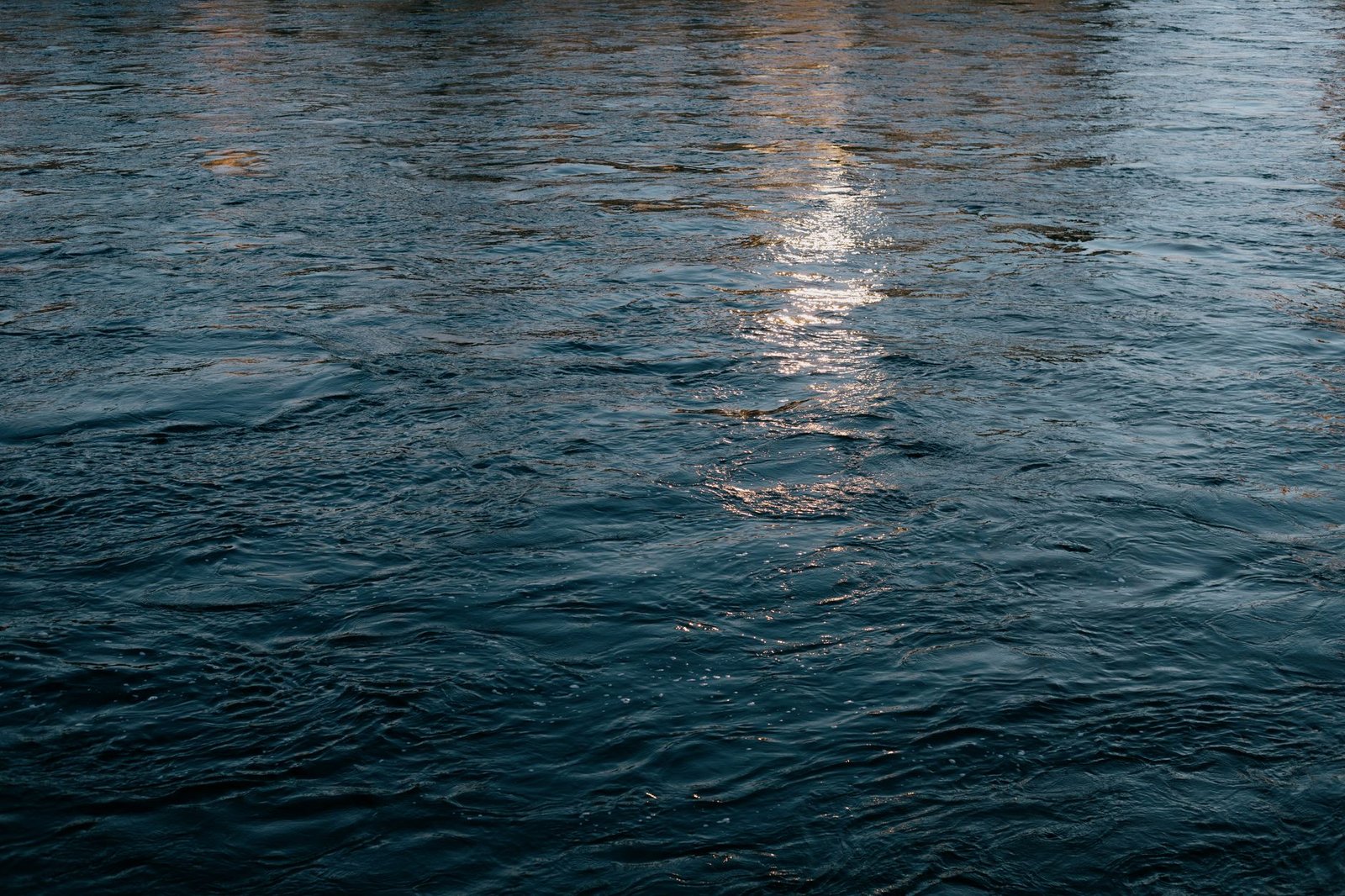 Calm water surface reflecting light in Inverness, Scotland.