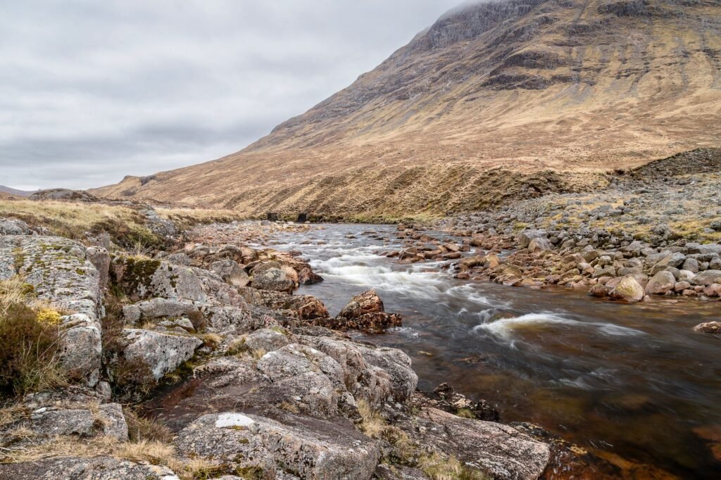 Captivating highland landscape with a serene river flowing through Glen Etive, Scotland. Ideal for nature lovers.