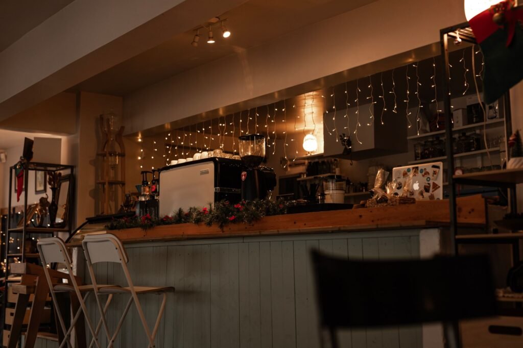 Warm and inviting café scene with festive lights and coffee equipment on display.