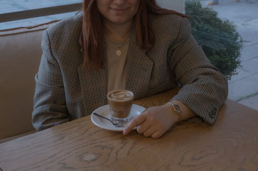 A person enjoying a cup of coffee in a cozy cafe, creating a relaxing atmosphere.