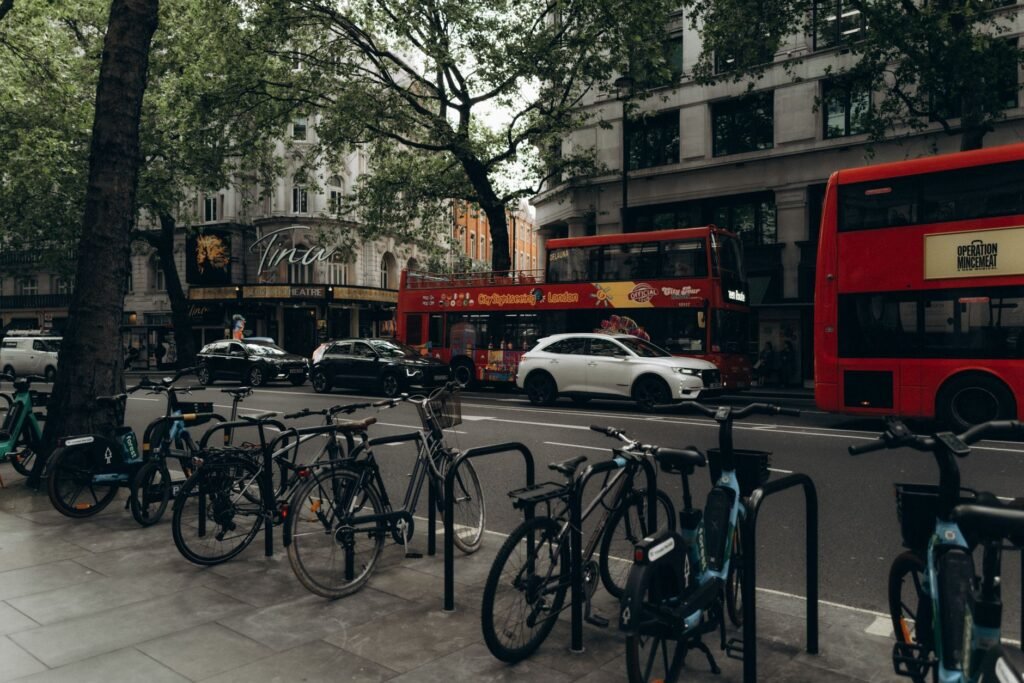 A bustling London street scene featuring bicycles and iconic red double-decker buses.