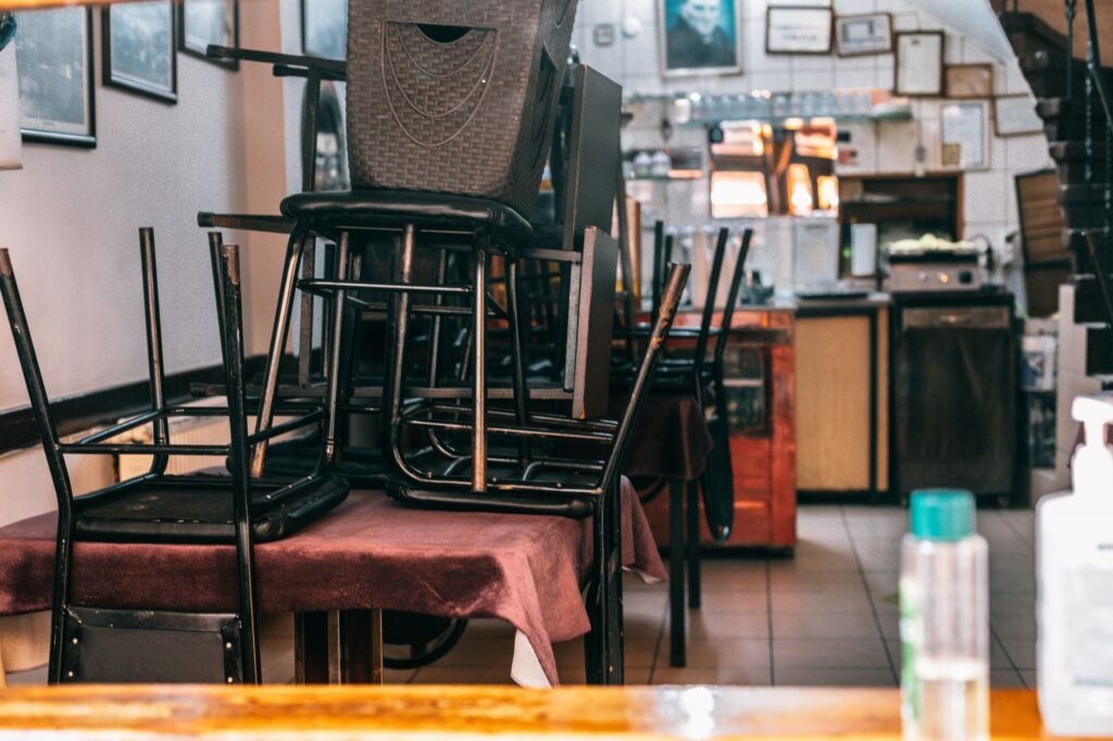 Modern cafe with kitchen and chairs on table before closing and prepared for cleaning