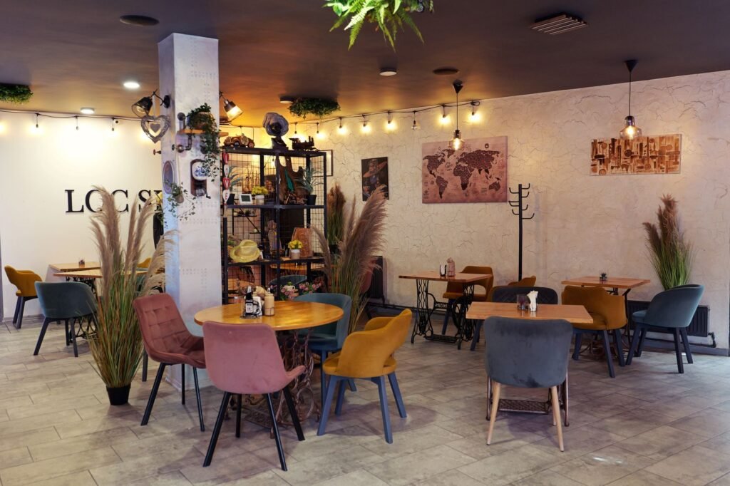 Inviting cafe interior with colorful seating, eclectic decor, and warm lighting.